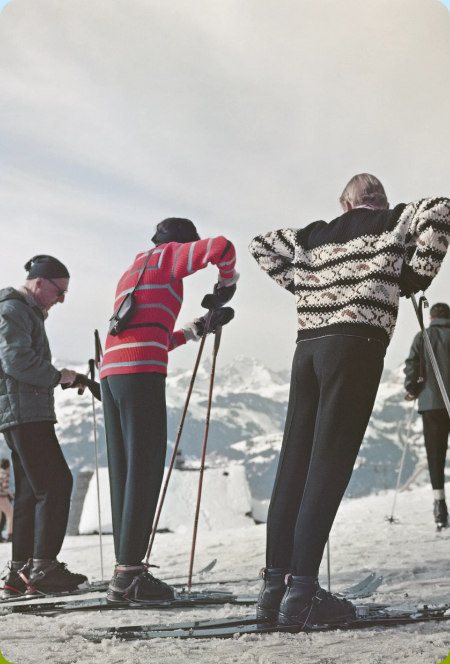 Skiers in patterned sweaters on a snowy mountain