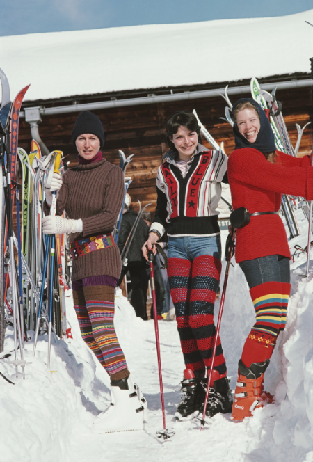 Three women in colorful vintage ski outfits